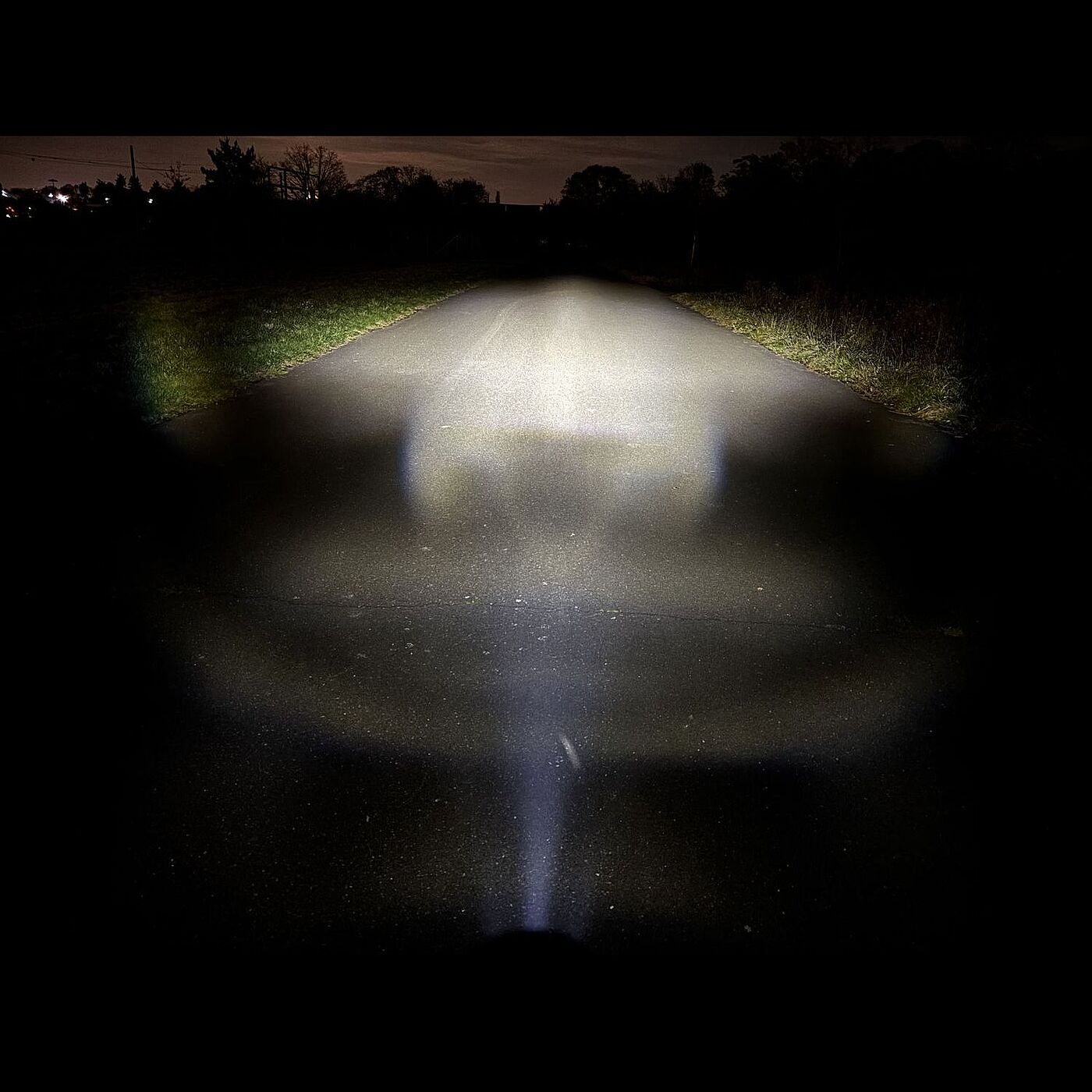 Cateye Nacht Der Lichtkegel des Cateye-Scheinwerfers in der höchsten Stufe in dunkler Umgebung.